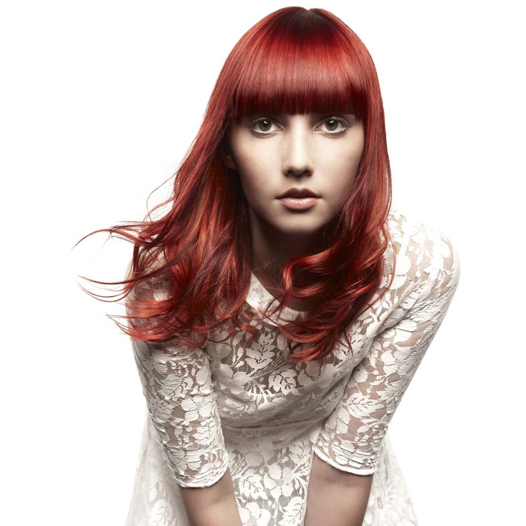 Red Hairstyles of woman with stylish bangs framing her face.