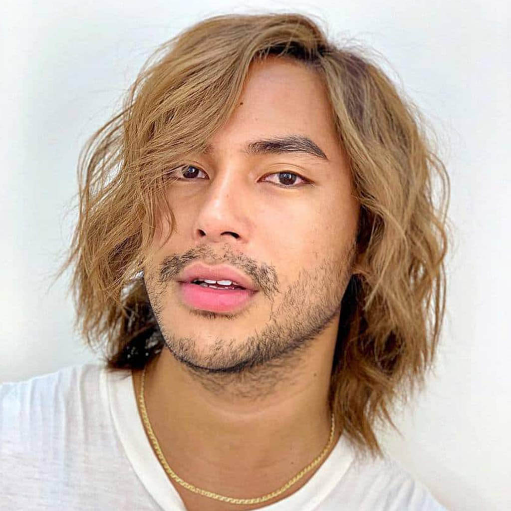 A man with a hair Cut styled into effortless and beachy waves