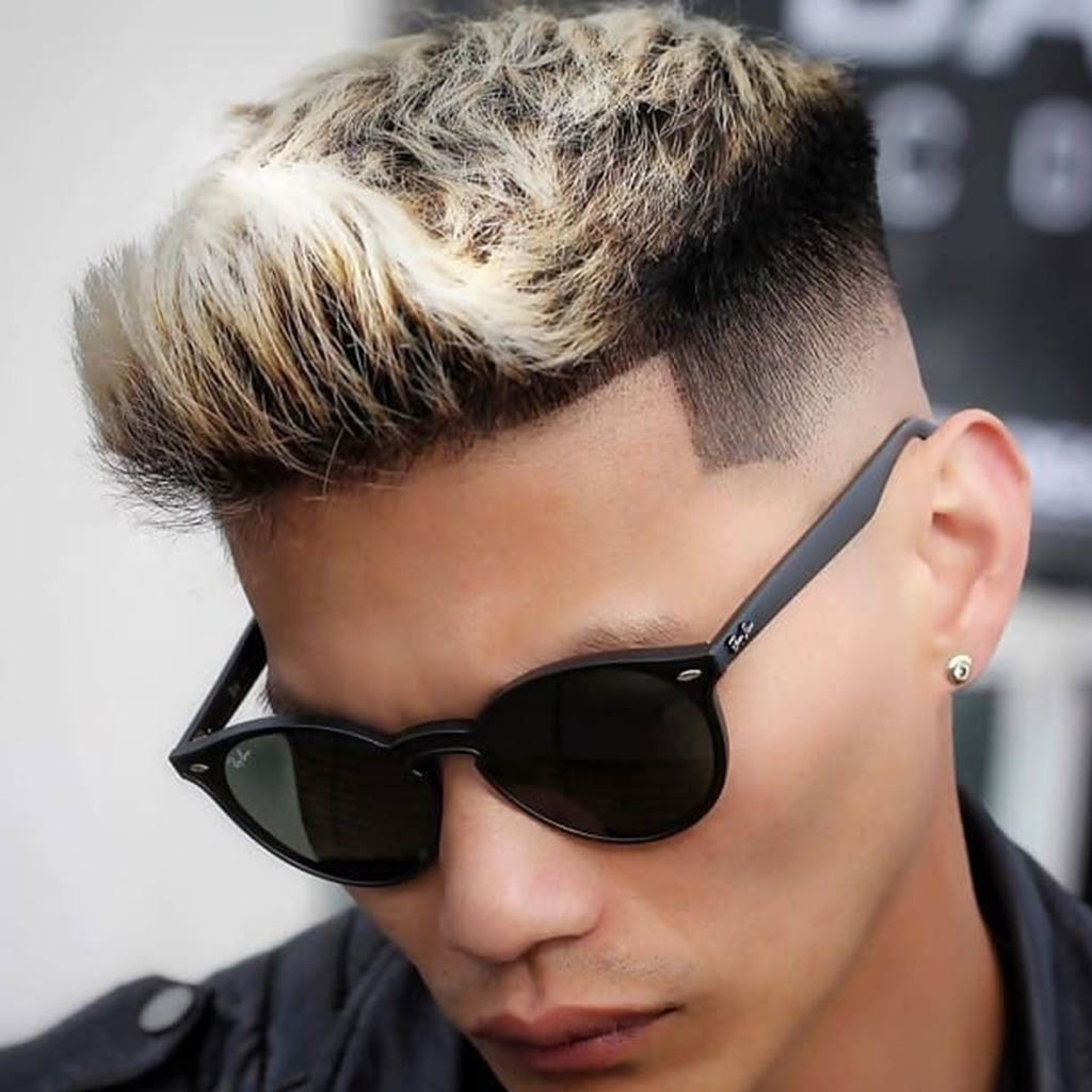 A man with frosted tips hairstyle, showcasing hair with bleached or colored tips for a bold and trendy look.