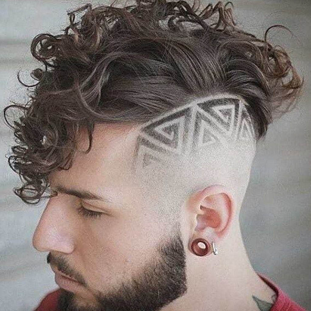 A man with a hair Cut complemented by a geometric fade, featuring precise lines and sharp angles