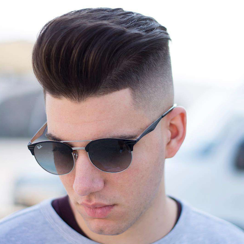 High Fade Pompadour Haircut For Men - A stylish men's hairstyle with a high fade and voluminous top.