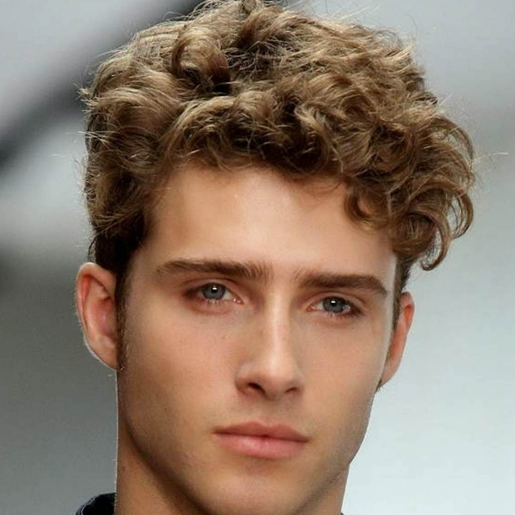 A man with messy curls hairstyle, showcasing a carefree and tousled look with natural and textured curls.