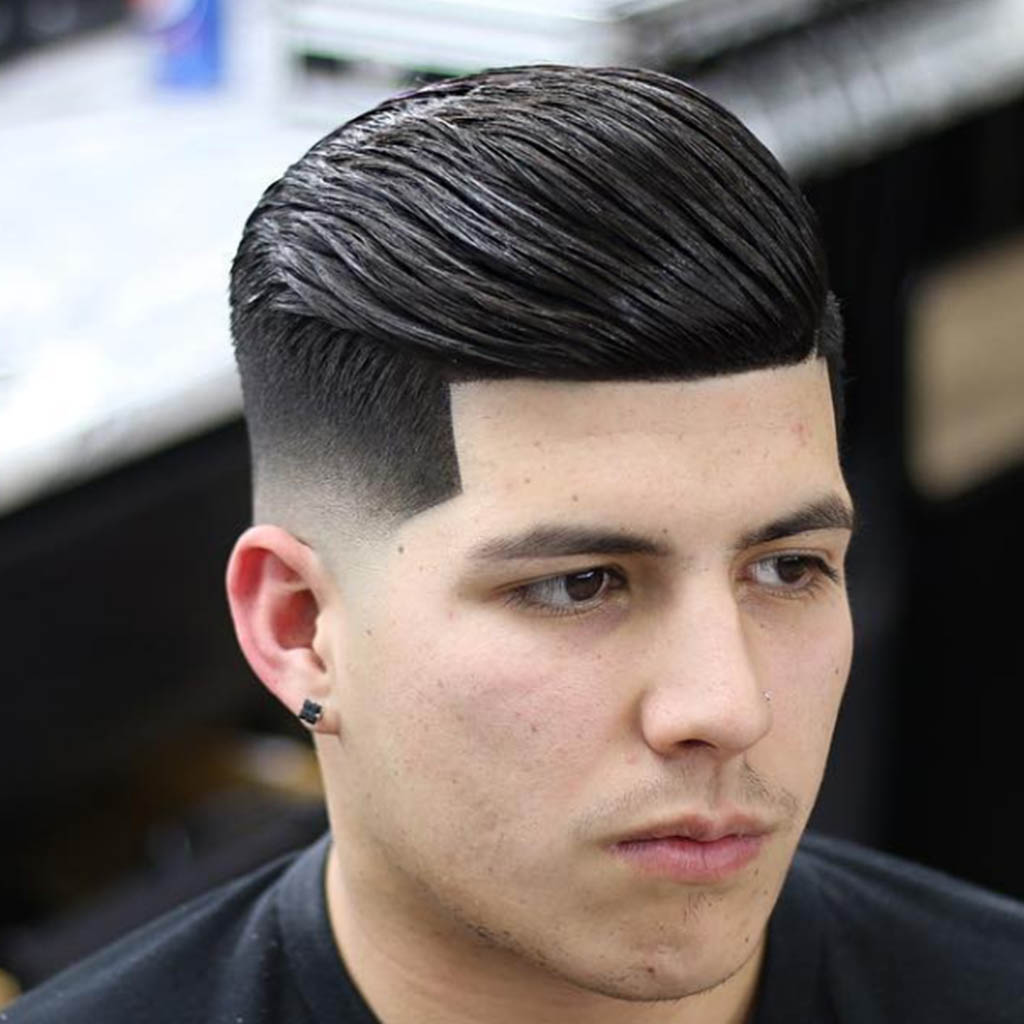 A man with a hair Cut featuring sharp and defined contours, creating a bold and structured look