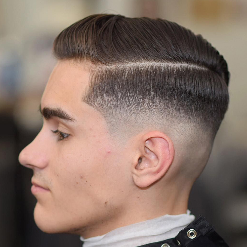 The Side Part Skin Fade - A sophisticated side part with a seamless skin fade.