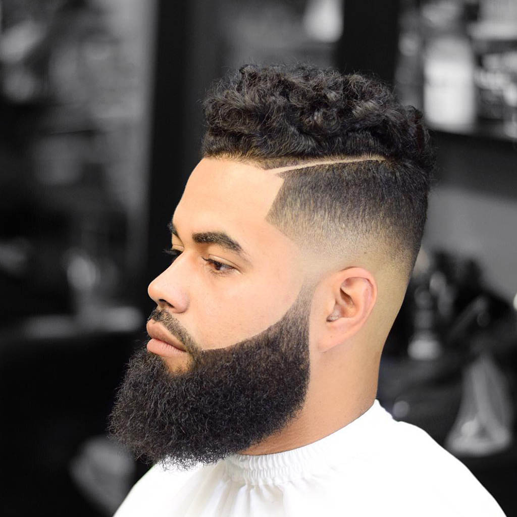 A man with side-swept curls hairstyle, showcasing voluminous and defined curls swept to one side.