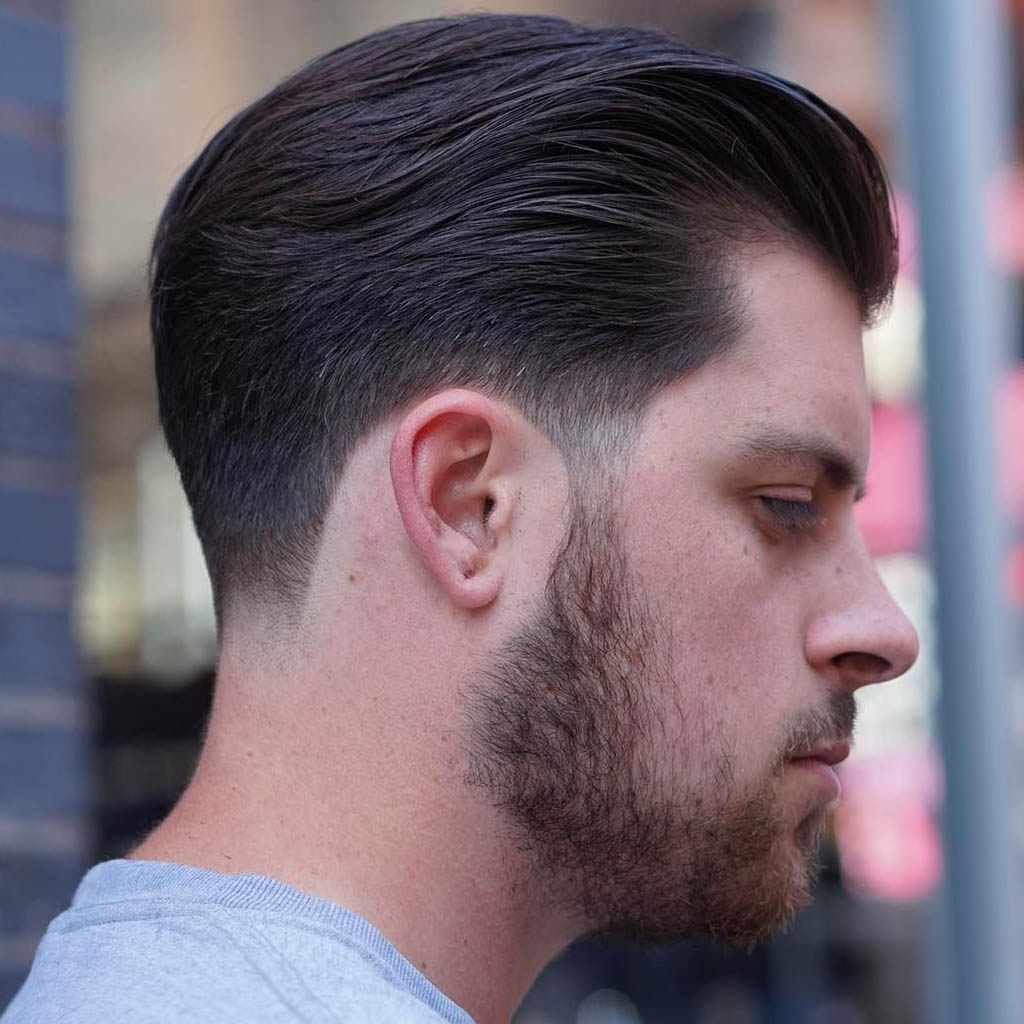 A man with a hair Cut styled with a sleek taper, combining sharpness and sophistication
