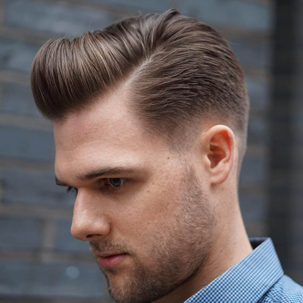 A man with a slicked-back and polished hairstyle