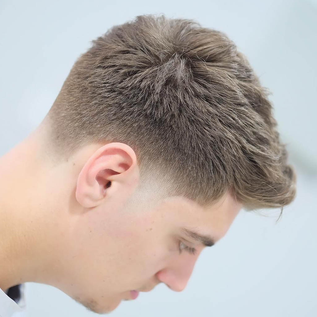 Man with a tapered Natural Hairstyles for Men, showcasing a gradual transition from shorter hair on the sides to longer hair on top.