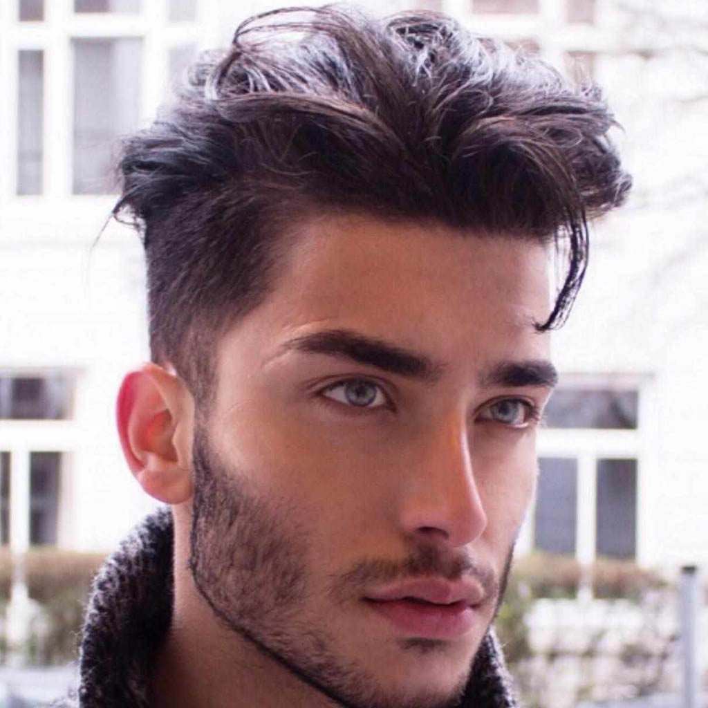A man with a hair Cut styled into a textured pixie cut, showcasing a bold and fashion-forward look