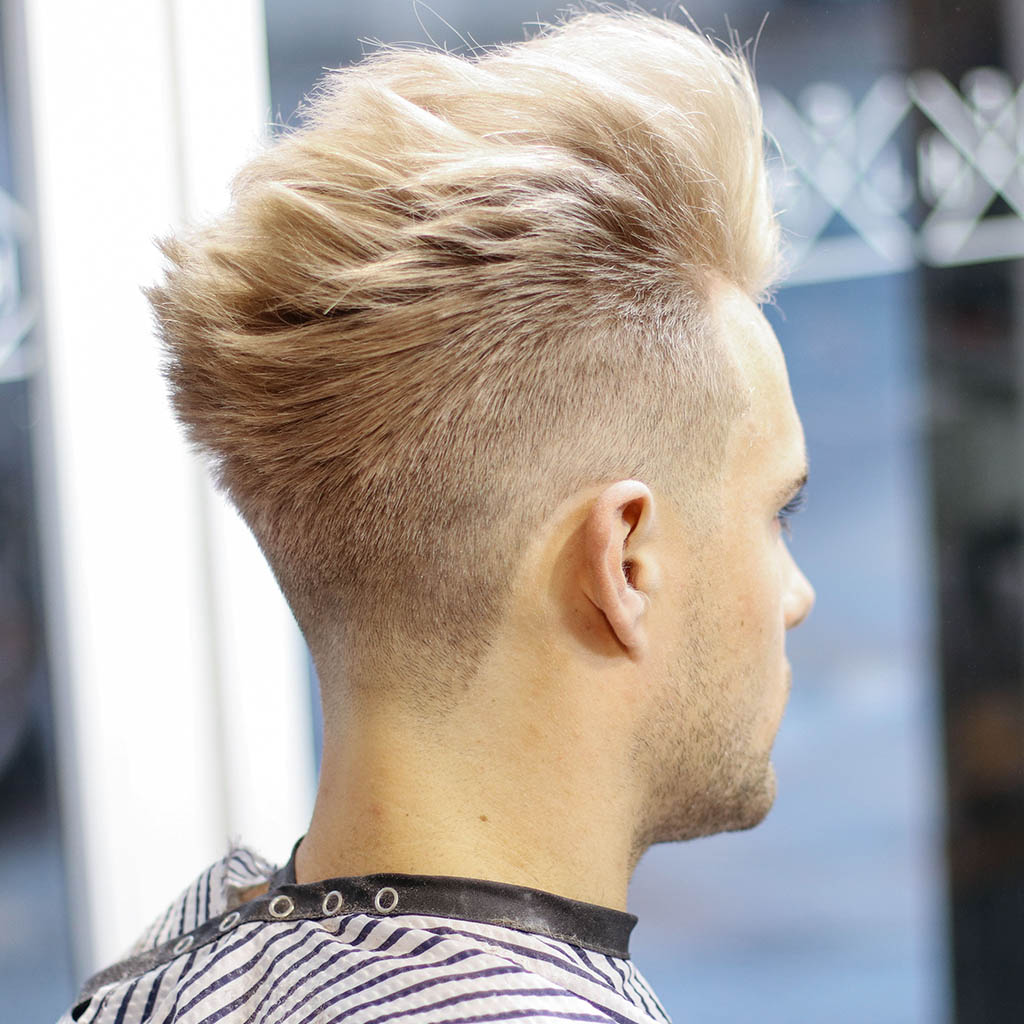 A man with a honey blonde pompadour, showcasing a classic and charismatic appearance.