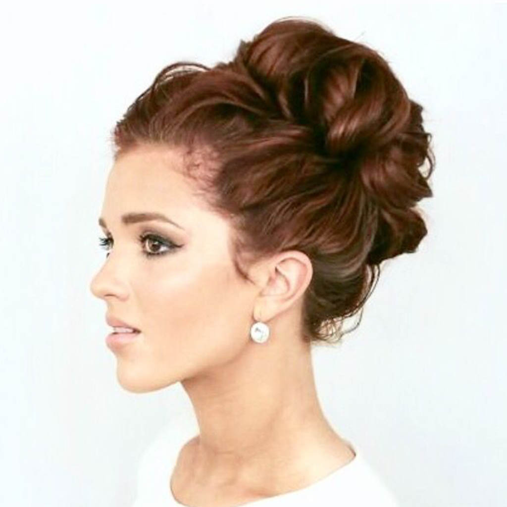 A woman with a sophisticated twist and tuck updo hairstyle.