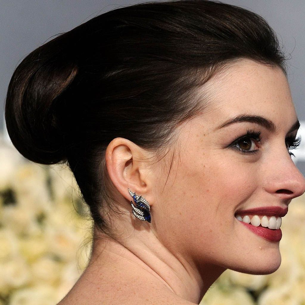 Anne Hathaway showcasing a textured updo with loose tendrils.